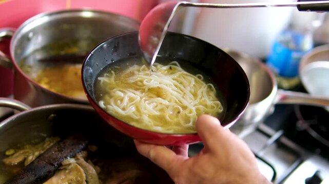 Authentic Vietnamese pho bo soup preparation process with pouring rich broth over rice noodles adding fresh herbs and assembling traditional ingredients in a flavorful culinary scene