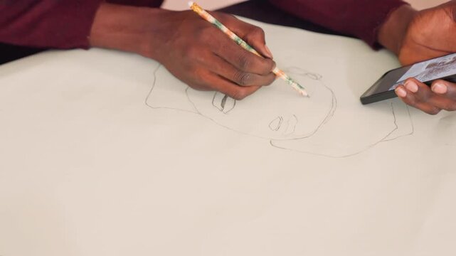 Black artist referencing phone while sketching on paper, closeup of dark hands tracing dotted guide, pencil tip and mobile reference visible, steady workspace, focused practice mood
