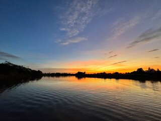 Obraz premium The view from the middle of the river shows both banks at sunset.