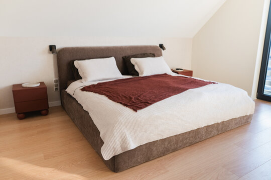 Modern Double Bed with White Linens in a Minimalist Attic Bedroom.