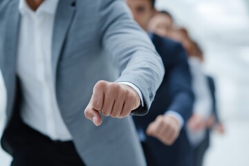 Fototapeta premium Male caucasian adult business team gesture with fist leading in a row dynamic office motion showing leadership focus determination and corporate momentum