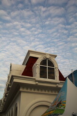 Obraz premium Classic European Style Roof with Arched Window and Cloudy Sky
