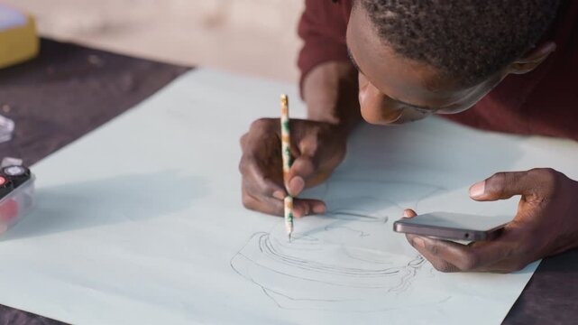 Overhead artist mapping composition paper, pencil tracing concentric lines while checking phone reference frames show roles as designer, cartographer, patternmaker, illustrator, planner steady hands,