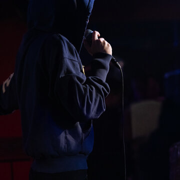 Faceless Rapper Performing with Microphone