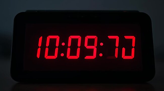 Close up studio shot of digital clock displaying an invalid time, ten minutes past seventy