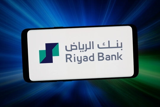 Stuttgart, Germany - 02-25-2026: In this photo illustration, the logo of Saudi Arabian financial company Riyad Bank is displayed on a smartphone in front of abstract background on computer screen.