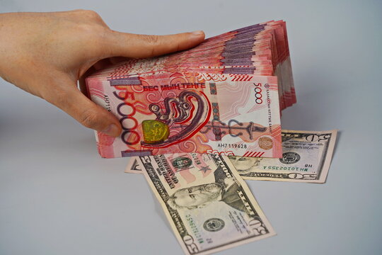 50 dollar bills and 5000 tenge banknotes on a paper background. Exchange rate, deposits, currency storage