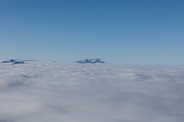 Stunning landscape of mountains peeking through a sea of clouds. Perfect for travel, nature, and adv