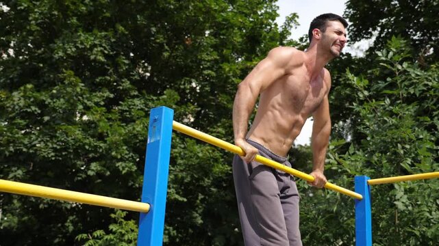 Athletic man performing dynamic workout routine on parallel bars, showcasing strength and determination through progressive motion in training environment, emphasizing physical fitness and dedication