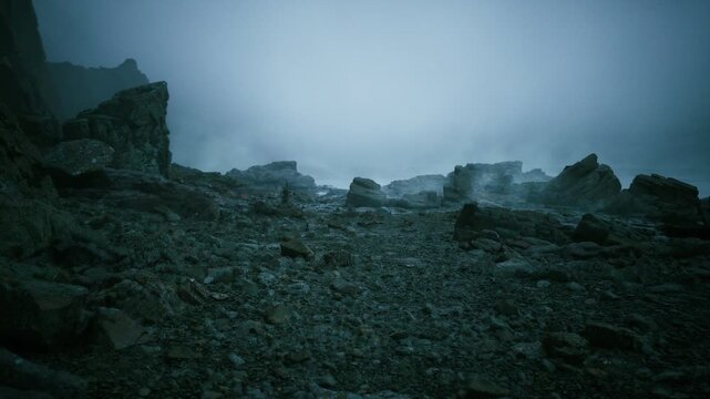 foggy rocky shore at twilight with pebblestrewn foreground, jagged basalt outcrops and low sea mist creating tealblue cinematic mood for atmospheric film