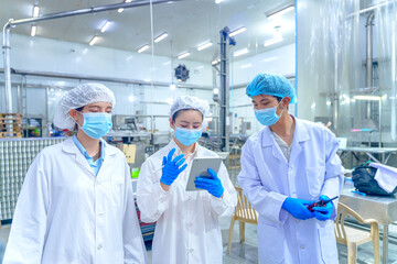 Group of workers check data in a food processing facility during the day