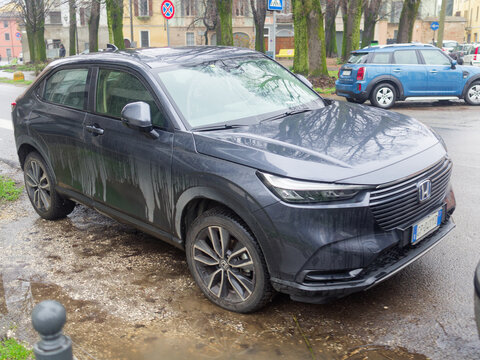 Honda HR-V e:HEV SUV parked on a city street, reflecting modernity, urban transportation, and sustainable hybrid technology during a damp day