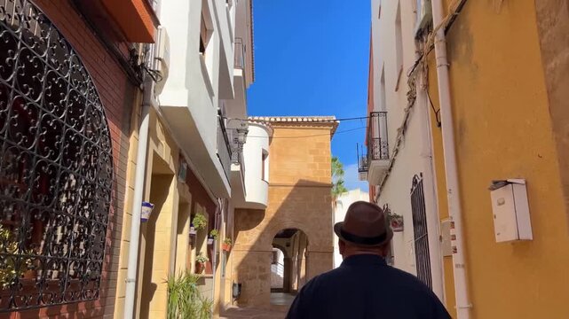 Hombre caminando hacia edificio antiguo en Teulada