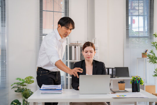 Female employee looks uncomfortable as male colleague invades her personal space and touches her arm at the office, illustrating workplace sexual harassment and power imbalance