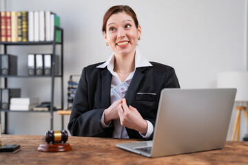 Fototapeta premium Female lawyer smiling and discreetly putting a stack of dollars into her suit pocket, symbolizing corruption and unethical legal practices in the office