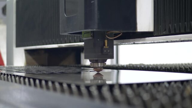 Advanced laser system cuts flat metal surface. Bright sparks on industrial manufacture. Concept of digital control, engineering accuracy and efficient production in heavy industry