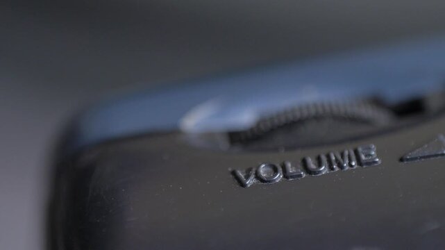 Close-up of volume mark beside gear wheel. Concept of control in user interface. Emphasis on mechanical simplicity. Connection between physical detail and audio function