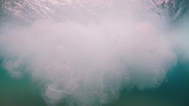 Surfer dives under the wave. Underwater footage of the surfer diving under the wave with surfing board