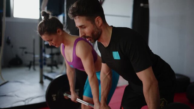 Focused Fitness Training: A Strongman and Woman Engage in Weightlifting Workout Technique at the Gym, Enhancing Strength and Form Together for Better Results