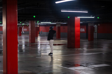 Person standing alone in empty underground parking garage