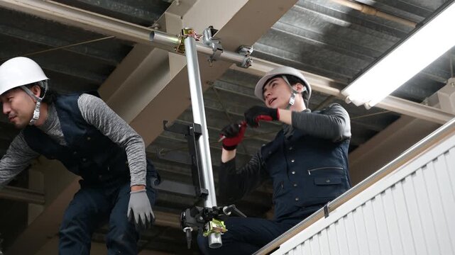 単管を設置する2人の日本人作業員