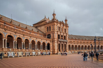 Fototapeta premium Plaza de Espana, Sivilla. Historic stone building with towers and courtyard under cloudy sky