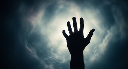 Silhouette of a Hand Reaching Towards the Light in the Sky.