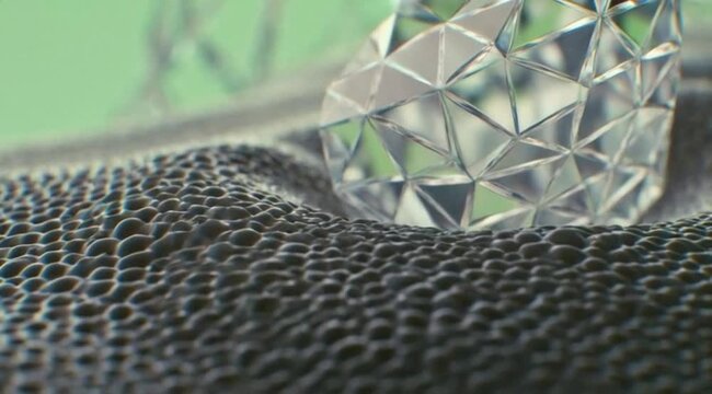 Close up of a clear faceted diamond crystal resting on a dark porous foam surface. Macro photography of a shiny transparent gem. Abstract luxury or science material concept.