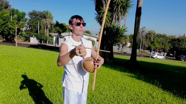 homem tocando musica com birimbau instrumento de capoeira 