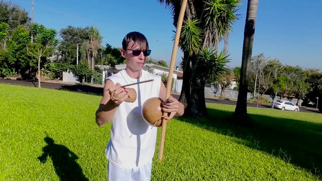 homem tocando musica com birimbau instrumento de capoeira 