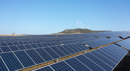 Solar Panels with Wind Turbines Under Blue Sky Renewable Energy Concept