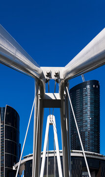 View of high rise through part of a large white ferris wheel