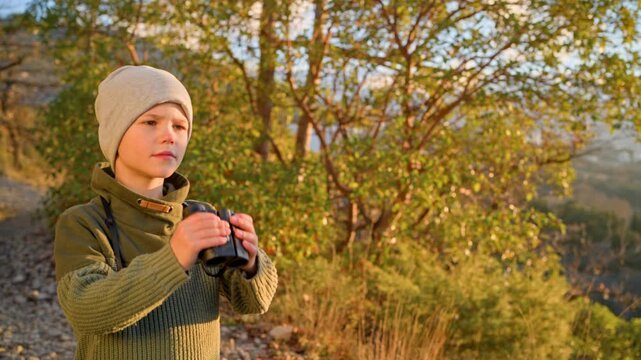 Child observing nature through optical glass tool. Focus on distance vision, outdoor hobby, wildlife study, and development of attention and curiosity in kids.