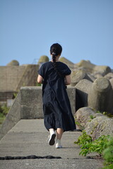 防波堤を歩く女性