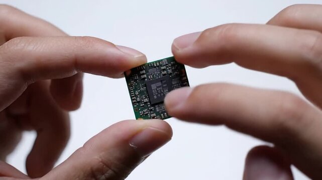 Hands holding a microchip with intricate circuits, showcasing artificial intelligence innovation in technology and modern electronics industry