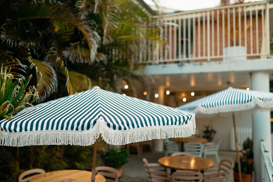 Blue and white striped beach umbrellas in alfresco dining area