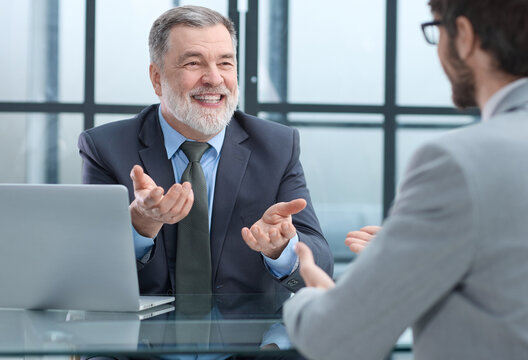 Two men are sitting at a table in a office