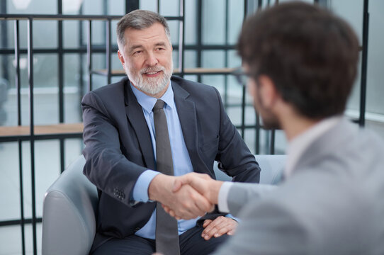 Two men shaking hands in a business setting