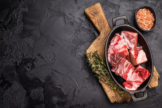 Raw chopped  lamb meat with bones, uncooked mutton ready for cooking. black background. top view