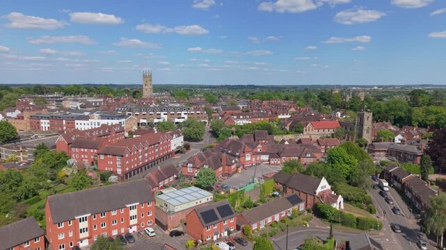 Drone ascending reveal of Warwick village on a sunny spring day, highlighting traditional English architecture, green countryside, and a peaceful historic town captured from above.