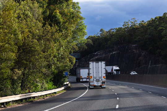 trucks traveling downhill in left lane on divided highway road in NSW Australia