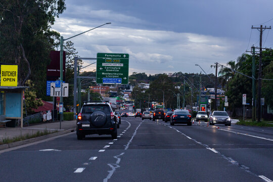 Busy city road with traffic stopping at lights at dusk