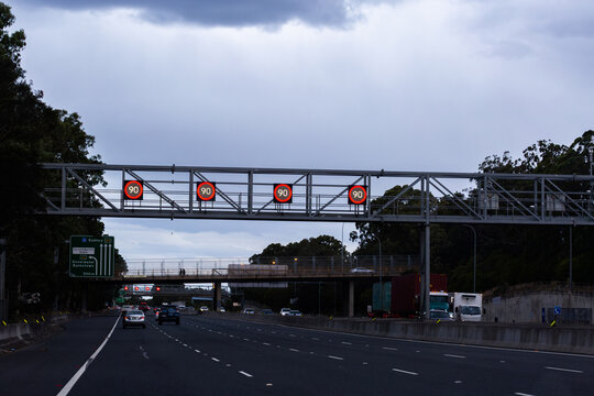 Overhead changeable digital 90 speed zone speed signs on metal structure above city road