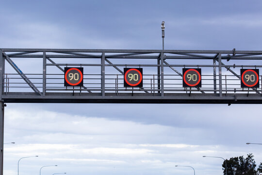 Overhead changeable digital 90 speed zone speed signs on metal structure above city road