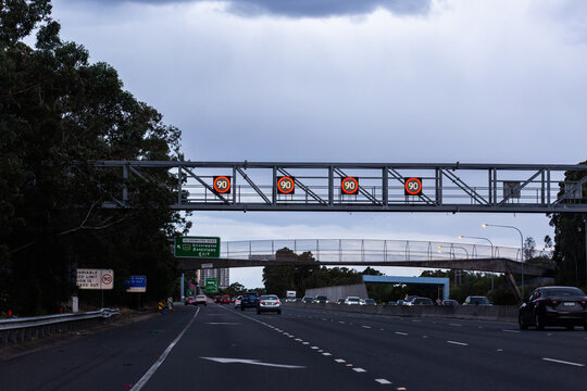 Overhead changeable digital 90 speed zone speed signs on metal structure above city road