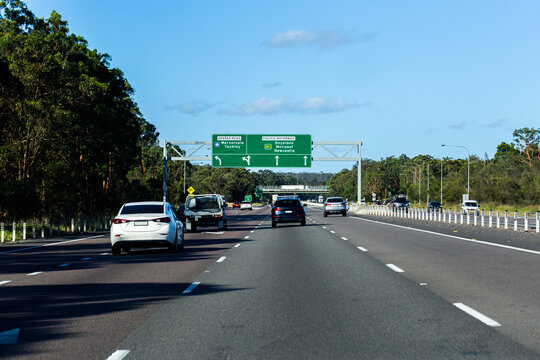 Green overhead sign with directions to sparks road warnervale and M1 pacific motorway