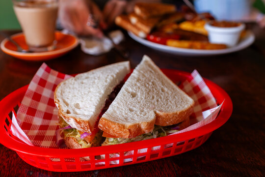 cut breakfast sandwich on table at caf&eacute;