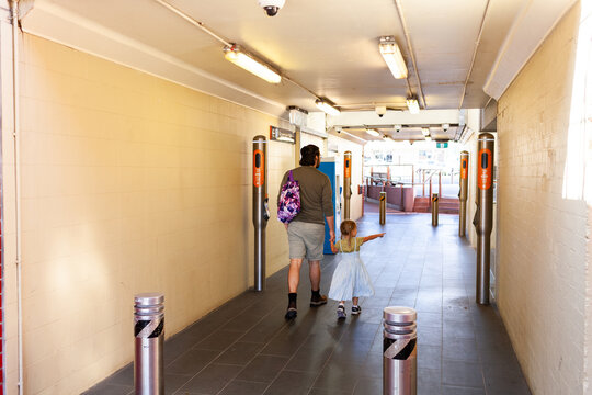 Tourists walking through train station platform area in city suburb dad with daughter