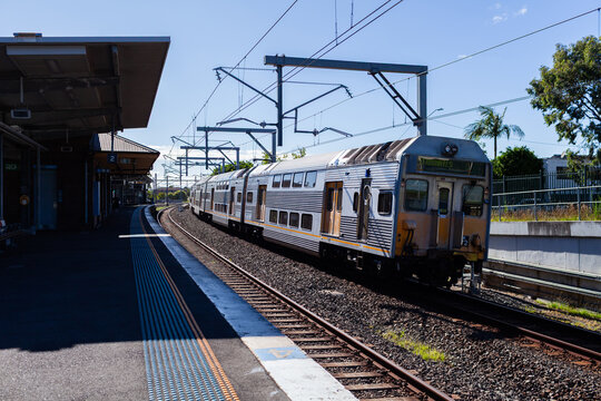 Passenger train passing platform of Narwee station in Sydney suburb