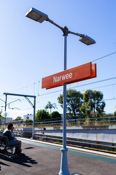 Narwee train station sign on post on platform in sunlight
